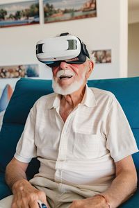 Excited senior man wearing vr goggles and enjoying playing video games.ai generated