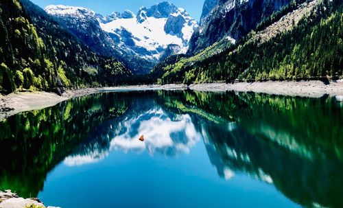 Scenic view of lake and mountains against blue sky