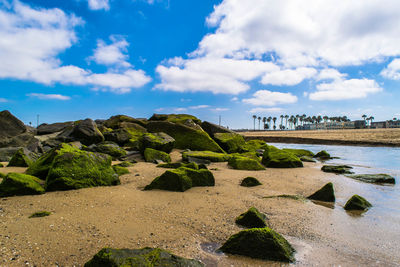 Scenic view of beach against cloudy sky