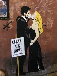 Man and woman with text on wall