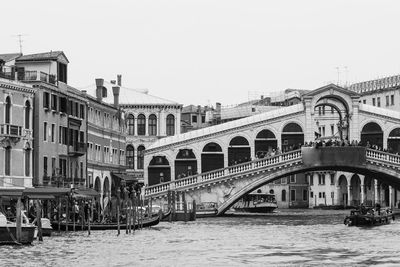 Bridge over canal in city against clear sky