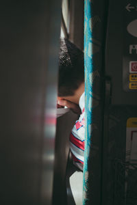 Rear view of boy looking through train window