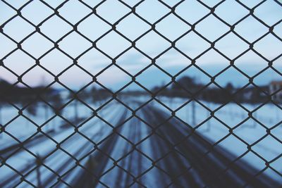 Close-up of chainlink fence against sky