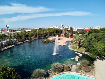 High angle view of lake against sky in city during sunny day