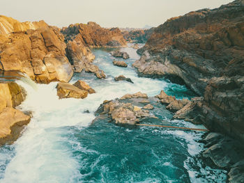 Scenic view of rocks in sea against sky