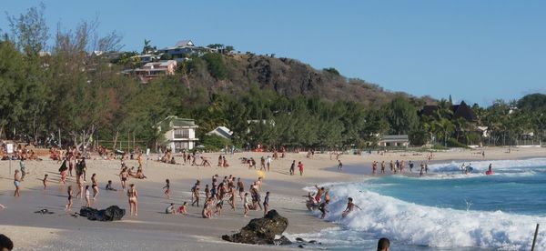 People at beach against clear sky