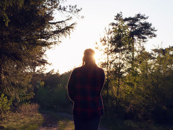 Rear view of person standing on field against clear sky at morning