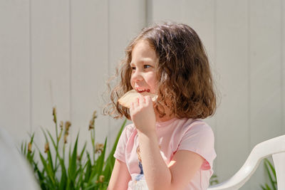 Expressive young girl is having snacks in the backyard