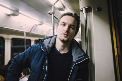 Portrait of young man standing on train