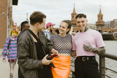 Cheerful non-binary friends enjoying and having fun in city