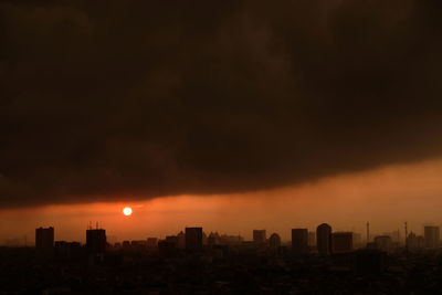 Buildings in city against sky during sunset