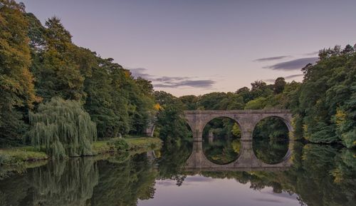 Arch bridge over river against sky