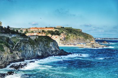 Scenic view of sea by buildings against sky