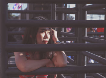 Portrait of woman sitting on window