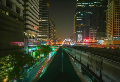 Illuminated street amidst buildings at night