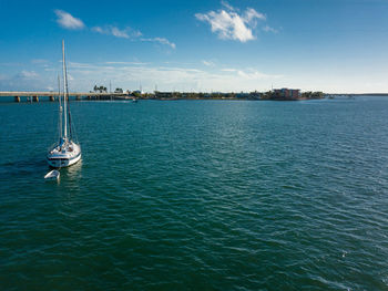 Sailboats in sea against sky
