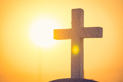 Close-up of cross against sky during sunset