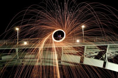 Low angle view of person spinning wire wool at bridge