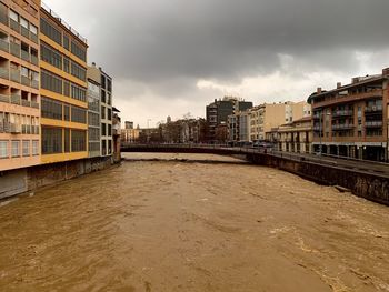 River amidst buildings against sky