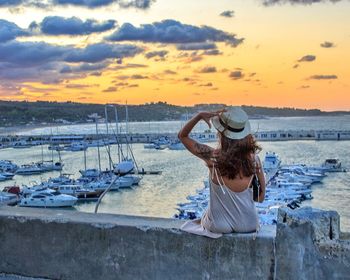 Rear view of woman in boat at sunset