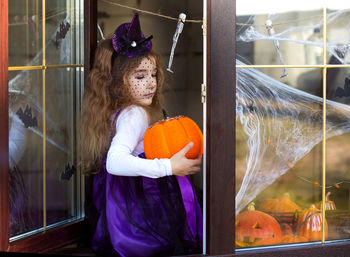 Full length of woman standing by pumpkin