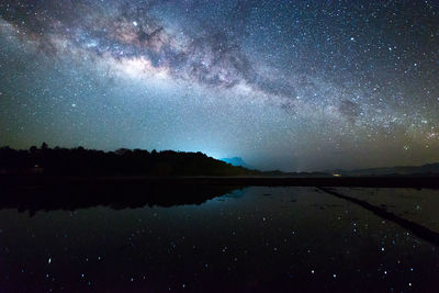 Scenic view of lake against sky at night