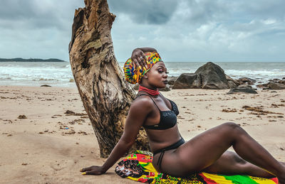 Ghana woman with a colorful blanket and headdress on a beach in ghana west africa