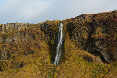 Scenic view of waterfall against sky