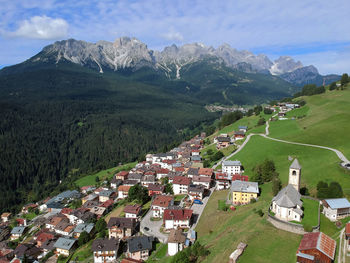 Aerial view of townscape by mountain against sky