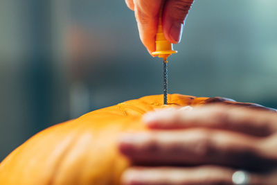 Close-up of hand holding orange leaf