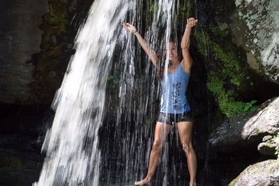 Portrait of smiling woman enjoying waterfall