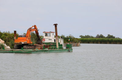 Barge on the river with a large digger for construction work