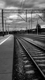 Railroad tracks against cloudy sky