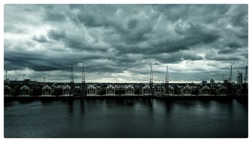 View of river in city against cloudy sky