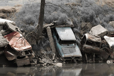 Abandoned car by lake during winter