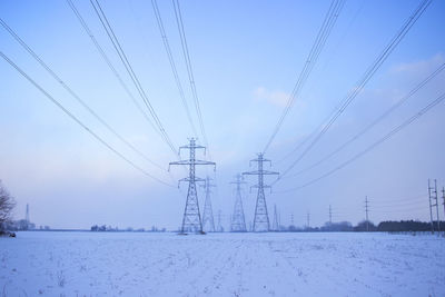 Electricity pylons against sky