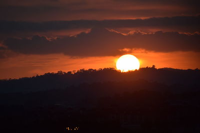 Scenic view of silhouette landscape against orange sky