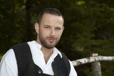 Close-up portrait of man against trees