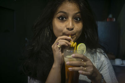 Portrait of young woman drinking glass