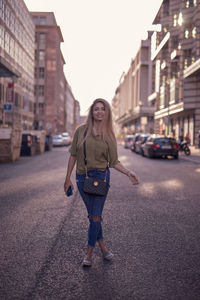 Portrait of woman walking on road in city