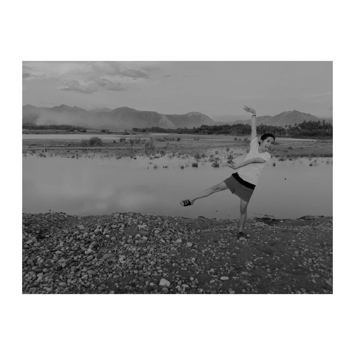 WOMAN ON BEACH AGAINST MOUNTAIN