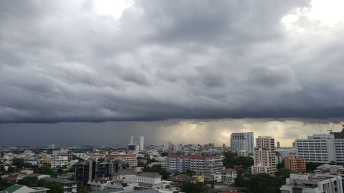 High angle view of buildings in city against cloudy sky