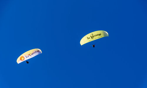 Low angle view of sign board against blue sky