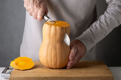 Midsection of man holding pumpkin on table