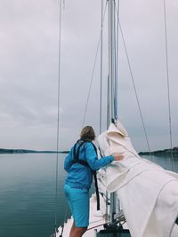 Rear view of sailboat sailing on sea against sky