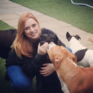 Portrait of smiling woman with dogs in yard
