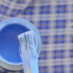 Close-up of blue paint on table against building