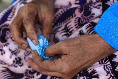 High angle view of senior woman hands holding handkerchief.