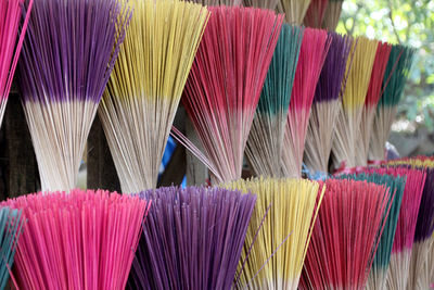 Close-up of multi colored brooms for sale at market