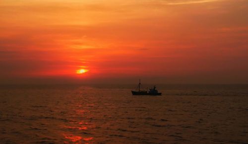 Scenic view of sea against orange sky